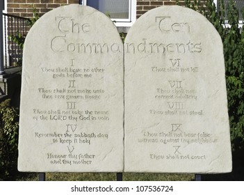 Two stone tablets engraved with the Ten Commandments in front of urban brick church