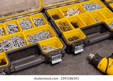 Two storage boxes on floor with small construction objects. Many storage compartments filled with accessories containing screws, nuts, bolts, nails and other tools. Home renovation background - Powered by Shutterstock