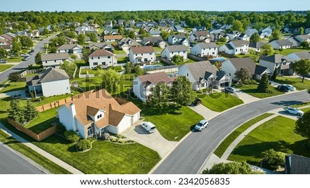 Two story houses in neighborhood aerial with cars in driveways and the street