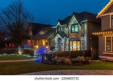 Two story stucco luxury house with garage door, big tree and nice Christmas decoration at night in Vancouver, Canada, North America. Night time on Dec 2021. - Powered by Shutterstock