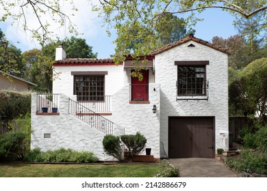 Two Story White Stucco House With Stairs And A Red Door