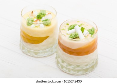 Two Striped Orange Jelly Glasses With Souffle And Cream Decorated By Mint