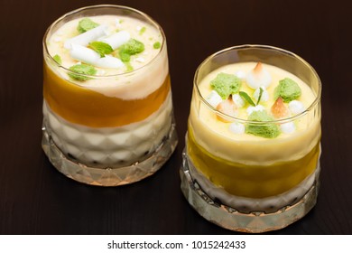 Two Striped Orange Jelly Glasses With Souffle And Cream Decorated By Mint