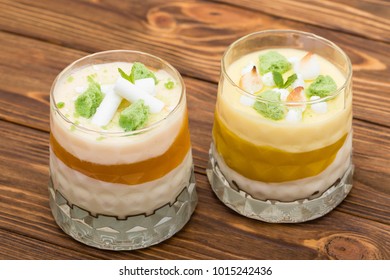 Two Striped Orange Jelly Glasses With Souffle And Cream Decorated By Mint