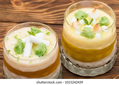 Two Striped Orange Jelly Glasses With Souffle And Cream Decorated By Mint