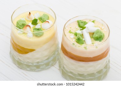 Two Striped Orange Jelly Glasses With Souffle And Cream Decorated By Mint