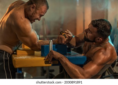 Two Strong Athletes In The Gym Compete In Arm Wrestling. Bodybuilders Armwreslers In Athletic Training Room