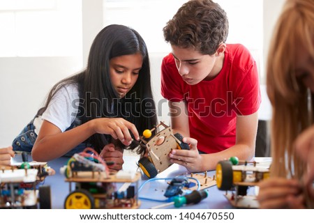Two Students In After School Computer Coding Class Building And Learning To Program Robot Vehicle