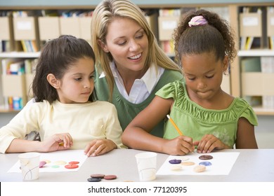 Two students in art class with teacher - Shutterstock ID 77120395