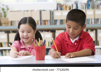 Two Students In Class Writing