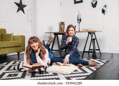 Two students doing homework together and helping each other sitting in a table at home with a homey background