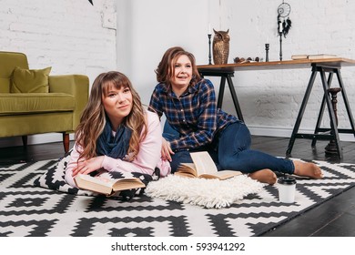 Two students doing homework together and helping each other sitting in a table at home with a homey background
