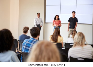 Two Students Giving Presentation To High School Class In Front Of Screen