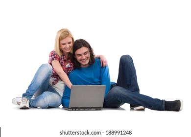 Two students with laptop. Smiling girl and boy sitting on the floor and using laptop. Full length studio shot isolated on white. - Shutterstock ID 188991248