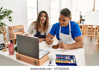 Two Students Smiling Happy Having Artistic Online Class Using Laptop At Art School.