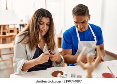 Two Students Smiling Happy Modeling Clay Sitting On The Table At Art School.