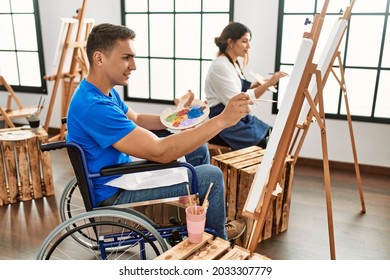 Two students smiling happy painting at art school 
