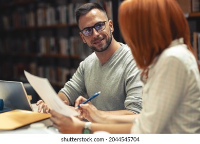 Two Students Study In The College Library.