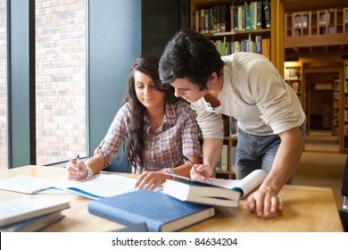 Two Students Working Together In A Library