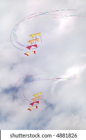 Two stunt kites flying in synchronization.