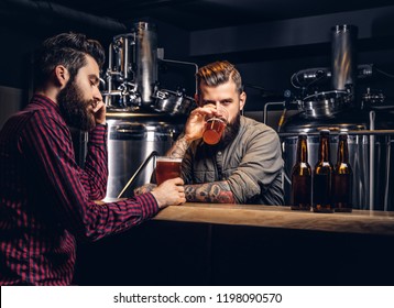 Two Stylish Bearded Hipsters Friends Drinking Craft Beer Together At The Indie Brewery.