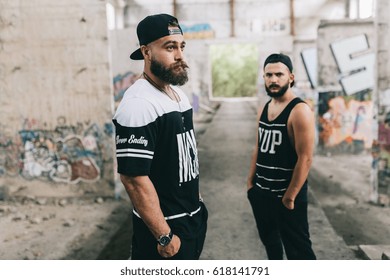 Two stylish bearded men posing on the industrial and urban place.