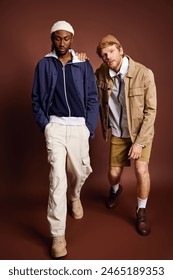 Two stylish multicultural men striding down runway together.