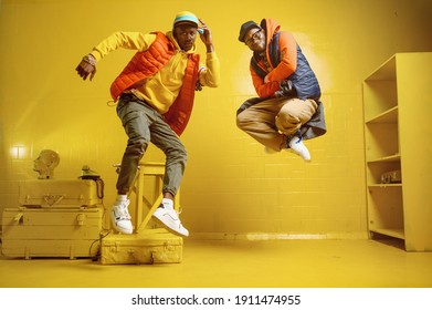 Zwei stylische Rappern im Studio, gelber Hintergrund