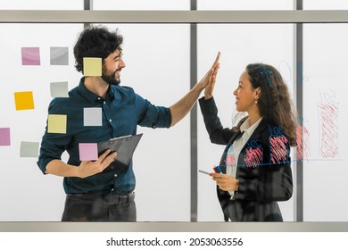 two success businessperson having high five after brainstorming and team discussing together for coporate planning in business office