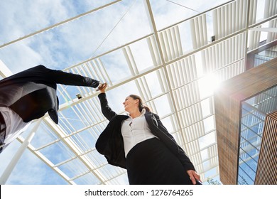 Two Successful Business People Make High Five In Front Of Business Office