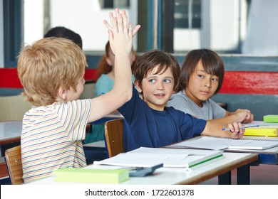 Two successful elementary school students clap their hands
