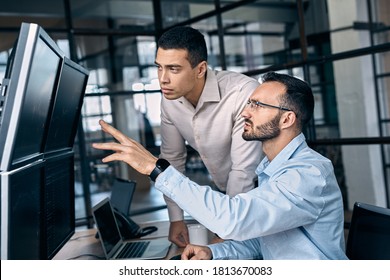 Two successful trader in formalwear pointing at display, analyzing stat and dynamic on forex charts, working in office together - Shutterstock ID 1813670083