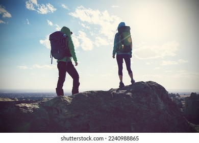 Two successful women backpackers standing on the  top frozen soil hill top - Shutterstock ID 2240988865