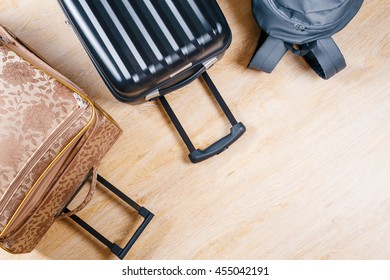 
two suitcases and a backpack lying on the floor at home