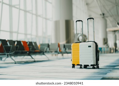 Two suitcases in an empty airport hall, traveler cases in the departure airport terminal waiting for the area, vacation concept, blank space for text message or design - Shutterstock ID 2348010941