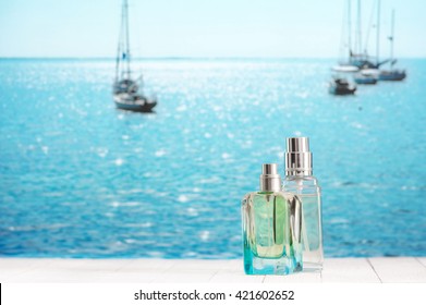 Two Summer Perfumes On White Wooden Table Against Defocused Sunny Sea With Yachts.