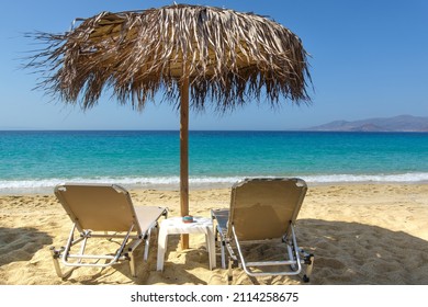 Two Sun Loungers And A Parasol On A Sandy Mediterranean Beach