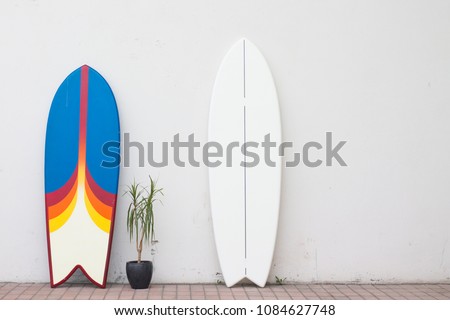 two surfboards on the street near the wall for hire rent