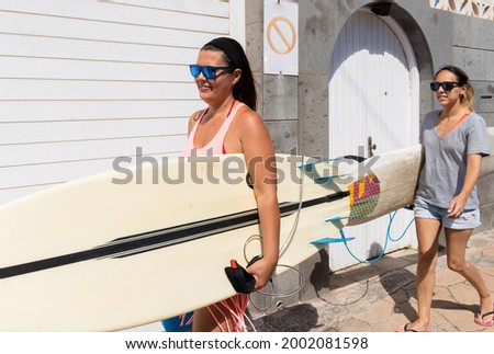 Similar – Surfer woman with bikini and wetsuit holding surfboard