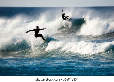 Two Surfers In Action On The Waves