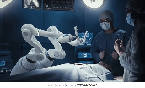 Two Surgeons Observing High-Precision Programmable Automated Robot Arms Operating Patient In Futuristic Hospital. Robotic Limbs Performing Advanced Nanosurgery, Doctors Looking At Vitals On Monitor