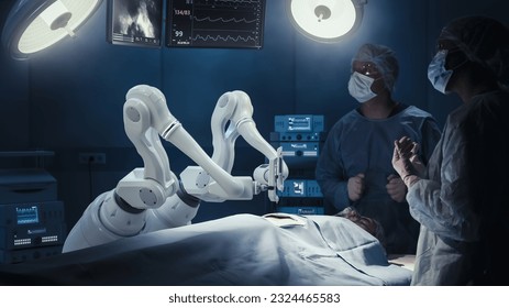 Two Surgeons Observing High-Precision Programmable Automated Robot Arms Operating Patient In High-Tech Hospital. Robotic Limbs Performing Complicated Nanosurgery, Doctors Looking At Vitals On Monitor.