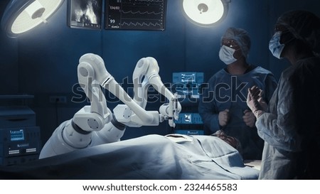 Two Surgeons Observing High-Precision Programmable Automated Robot Arms Operating Patient In High-Tech Hospital. Robotic Limbs Performing Complicated Nanosurgery, Doctors Looking At Vitals On Monitor.