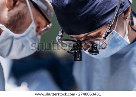 Two surgeons performing an operation with full concentration in a sterile operating room. Concept of medical technologies and surgery.
