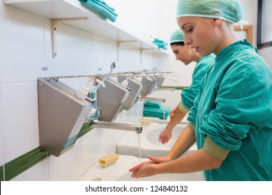 Two surgeons washing their hands in a hospital sink - Powered by Shutterstock