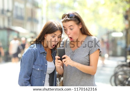 Similar – Two women laughing looking at their smart phone