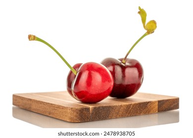 Two sweet cherries with wooden tray, macro, isolated on white background.