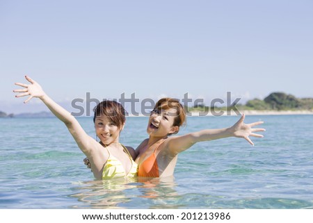 Two swimsuit women playing in the sea