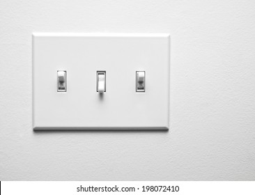Two switches turned on and one turned off on a panel.