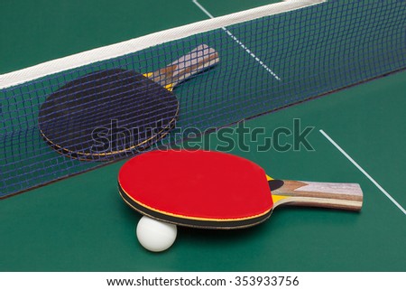 two table tennis racket red and black on a green table